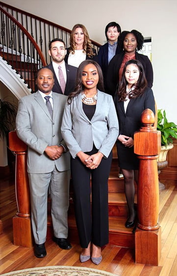 RI Personal Injury & Immigration Attorney Saikon Gbehan Isijola standing with a group of pers on a staircase