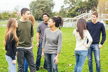 Diverse group of yong adults talking in a back yard