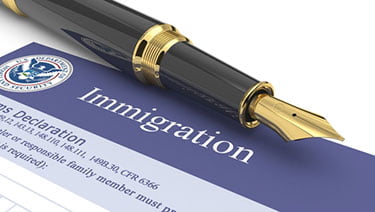Immigration form with black and gold fountain pen